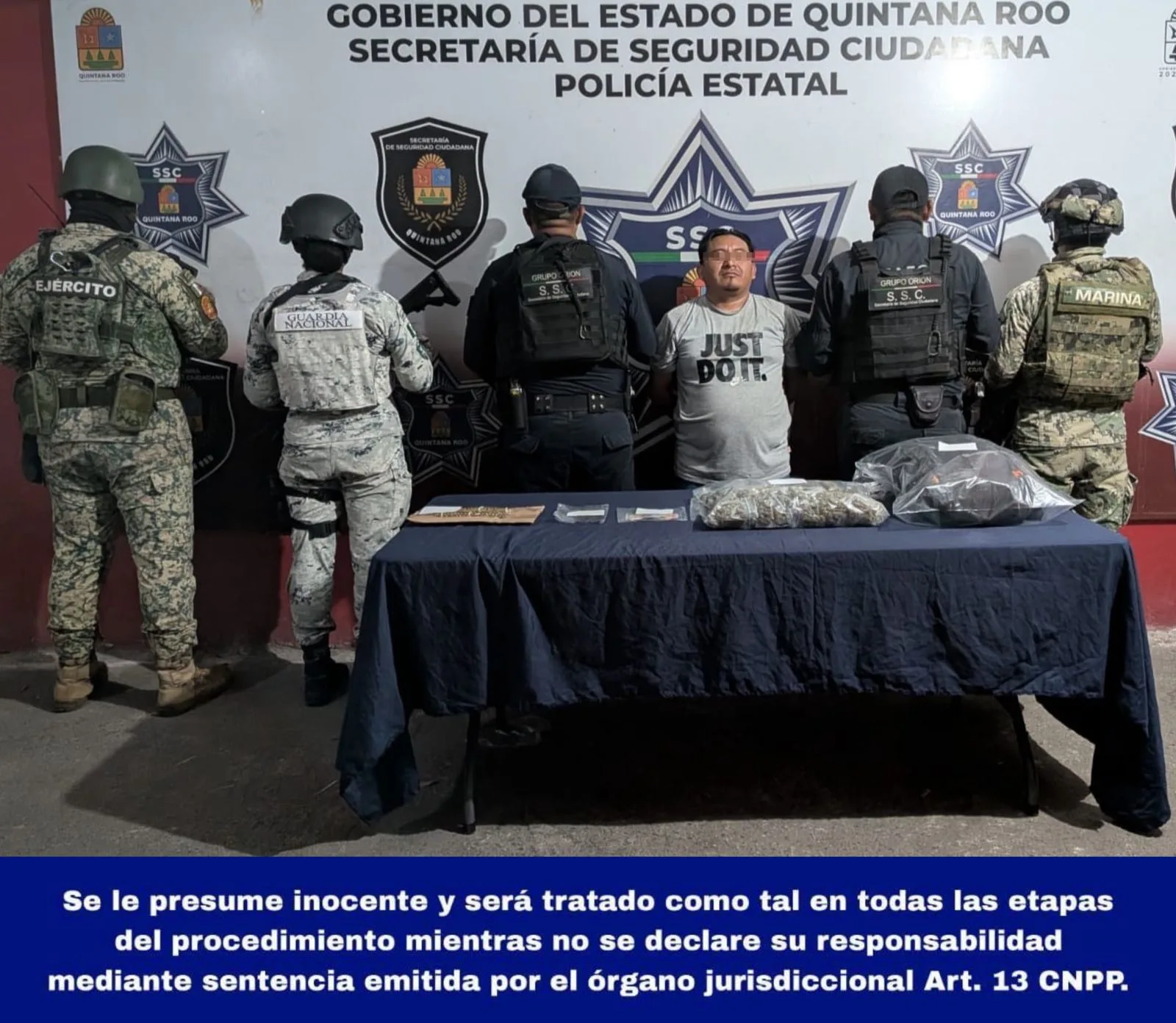 Police officers detain a man next to a black vehicle on a Cancun street