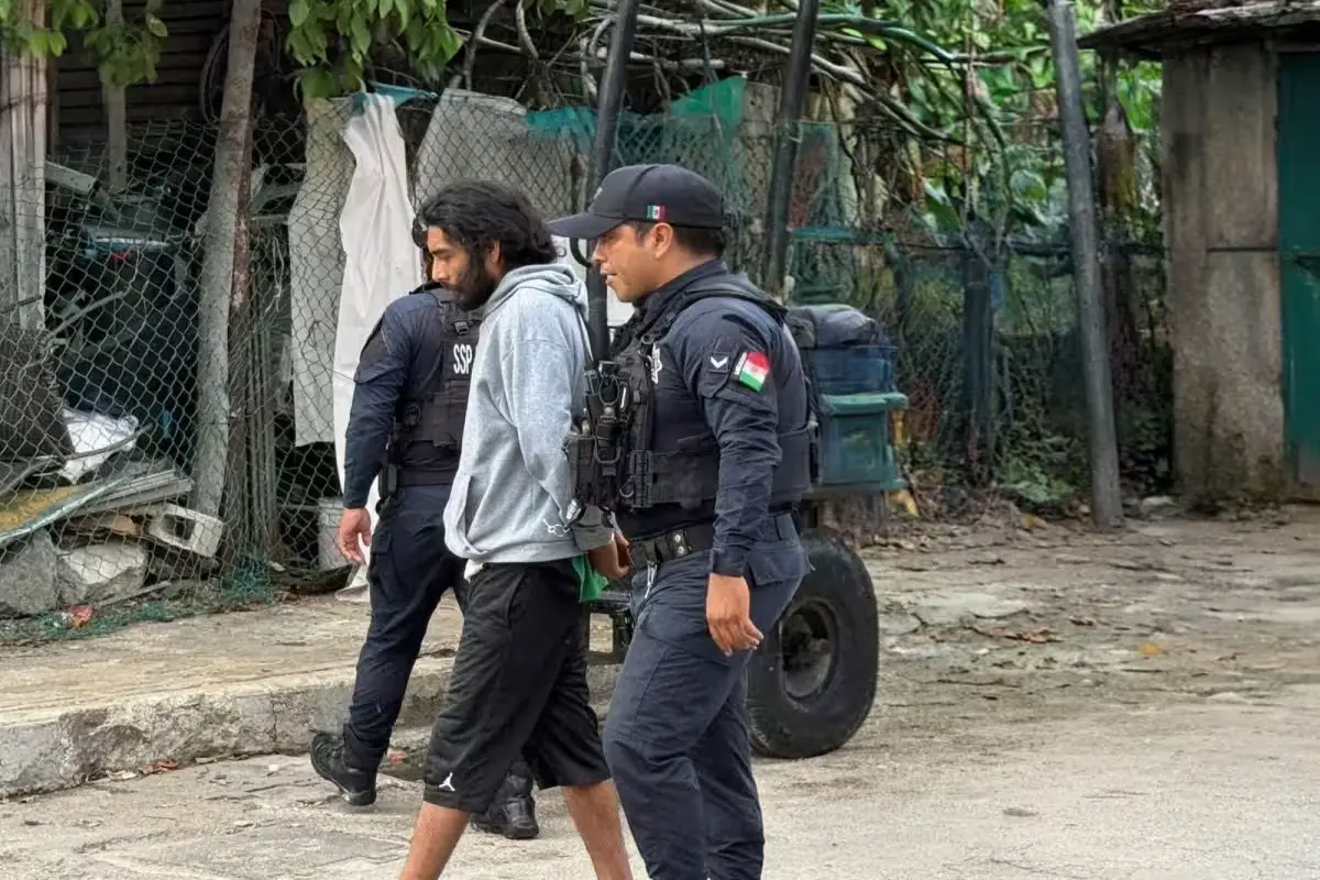 Police officers detaining a suspect at the scene of a machete attack in Playa del Carmen