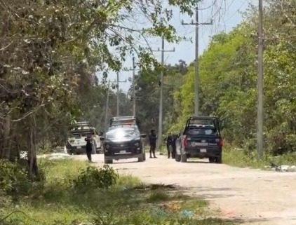 Police officers securing the scene where a dismembered body was found in an abandoned refrigerator in Cancun's Region 252