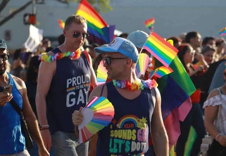 People at a Pride march on Holbox island with colorful flags and festive atmosphere