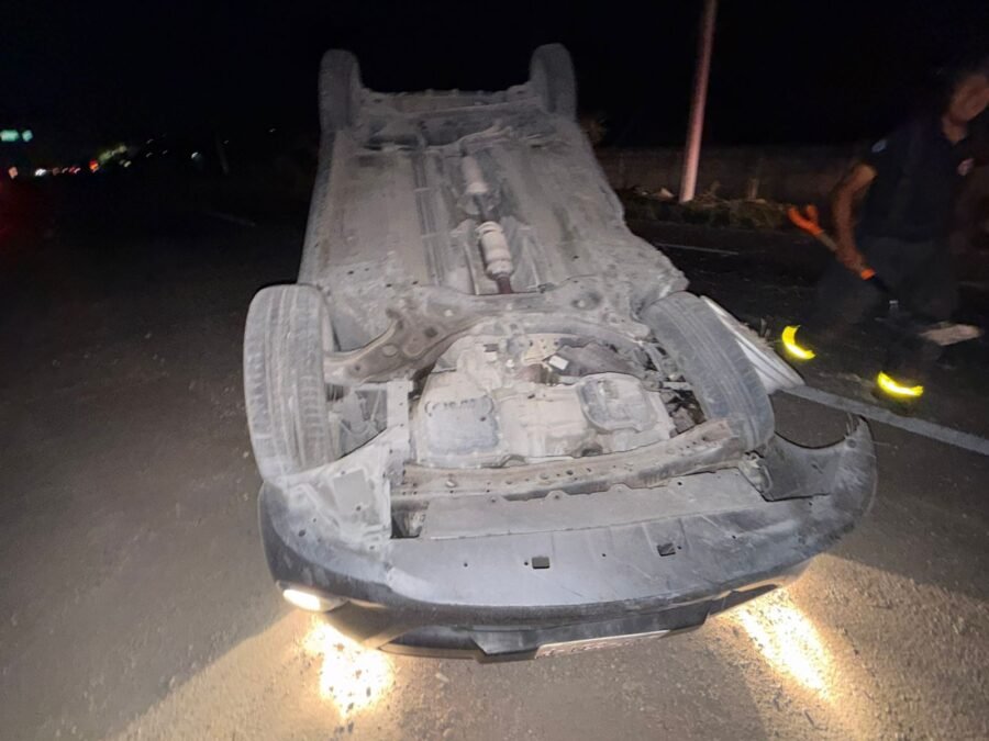 A gray Nissan March overturned on Highway 307 with emergency responders at the scene