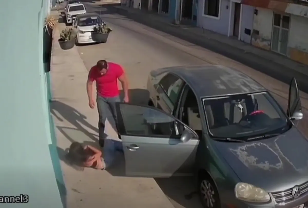 Security camera still showing a man pulling a woman out of a car on Avenida 1 de Mayo in Merida