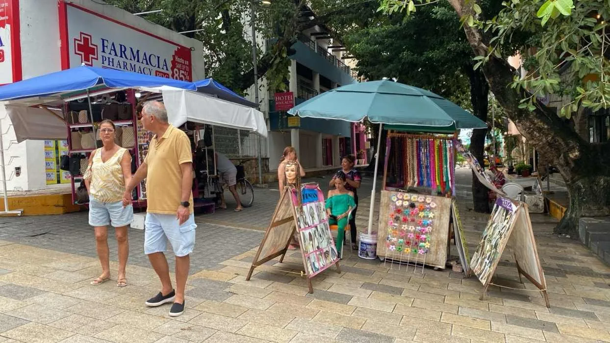 Street vendors selling goods on a sidewalk in Playa del Carmen, Quintana Roo