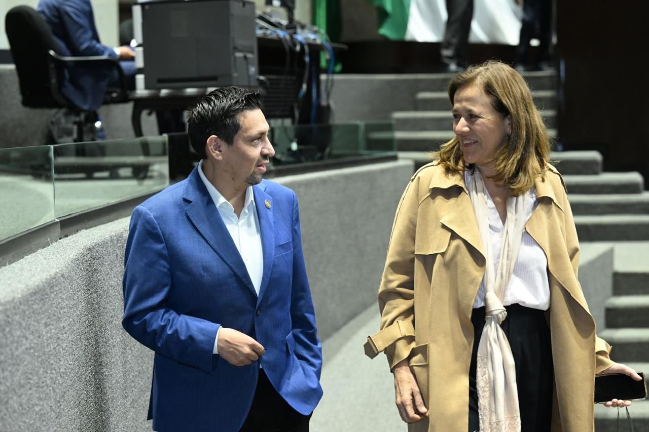 A taxi driver and a tourist standing by a taxi in Cancun, Mexico