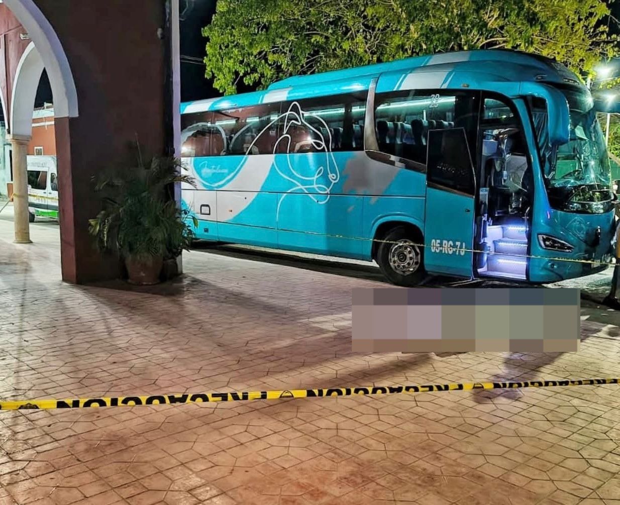 A tourist bus stopped on a road in Dzitas, Yucatan, where an American passenger died.