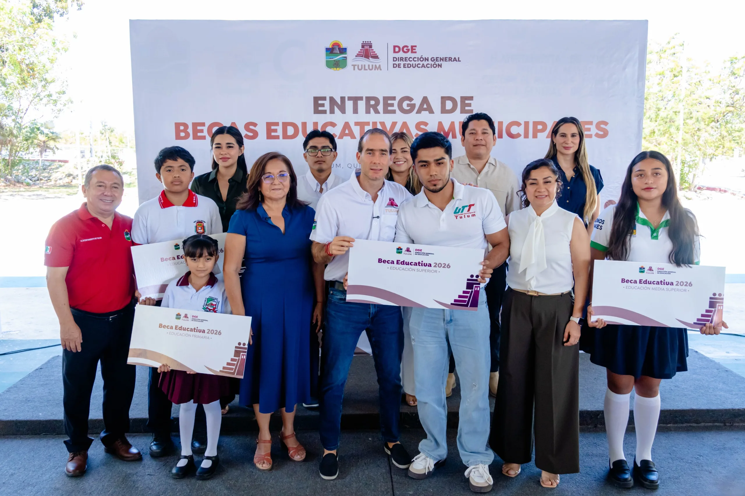 Tulum Mayor Diego Castanon Trejo presents scholarships to students at an award ceremony.