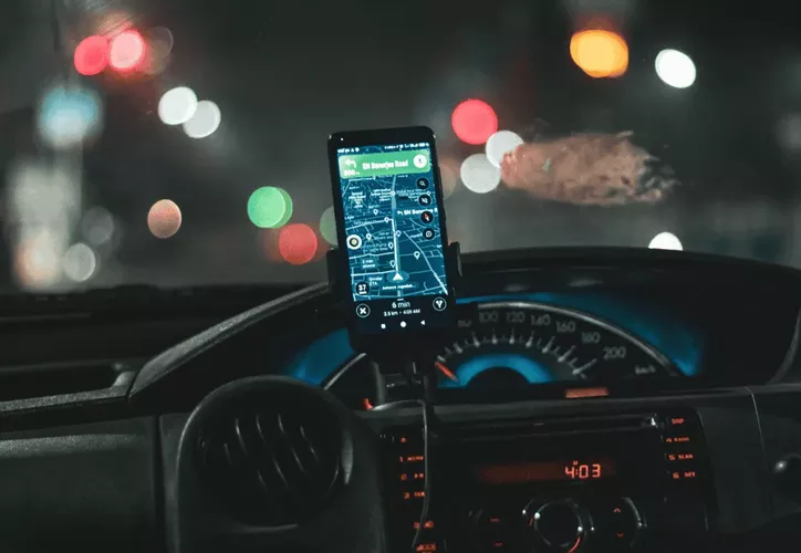 Smartphone displaying Uber app with Cancun airport in background, symbolizing ride-hailing preparations for World Cup tourists