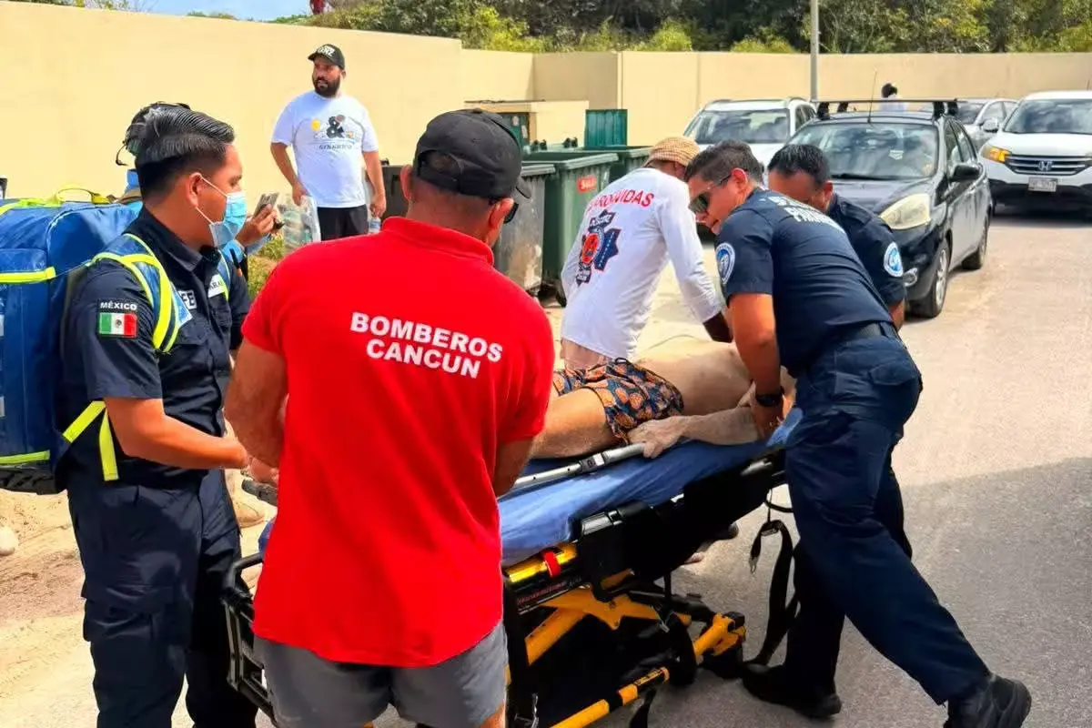 Emergency responders attend to a young man on a Cancun beach after a near-drowning incident