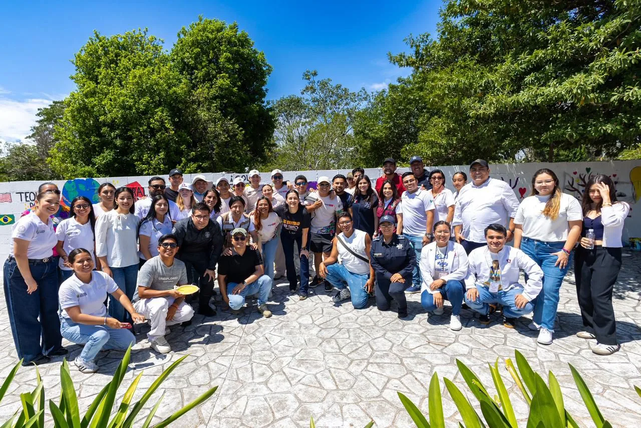 Young people painting a colorful mural with environmental themes in a park in Playa del Carmen, Quintana Roo.