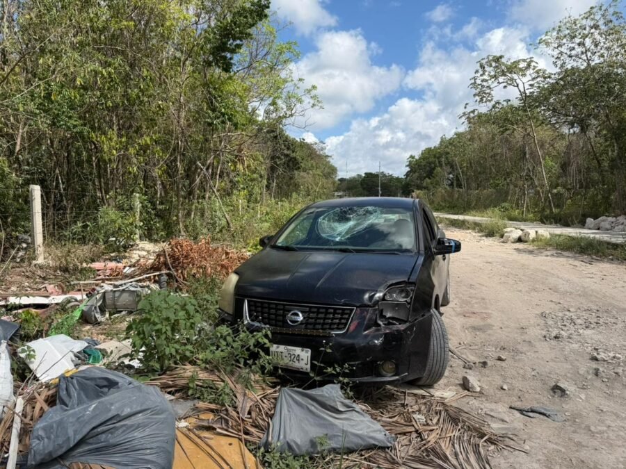 Black Nissan Sentra abandoned on dirt road in Cancun