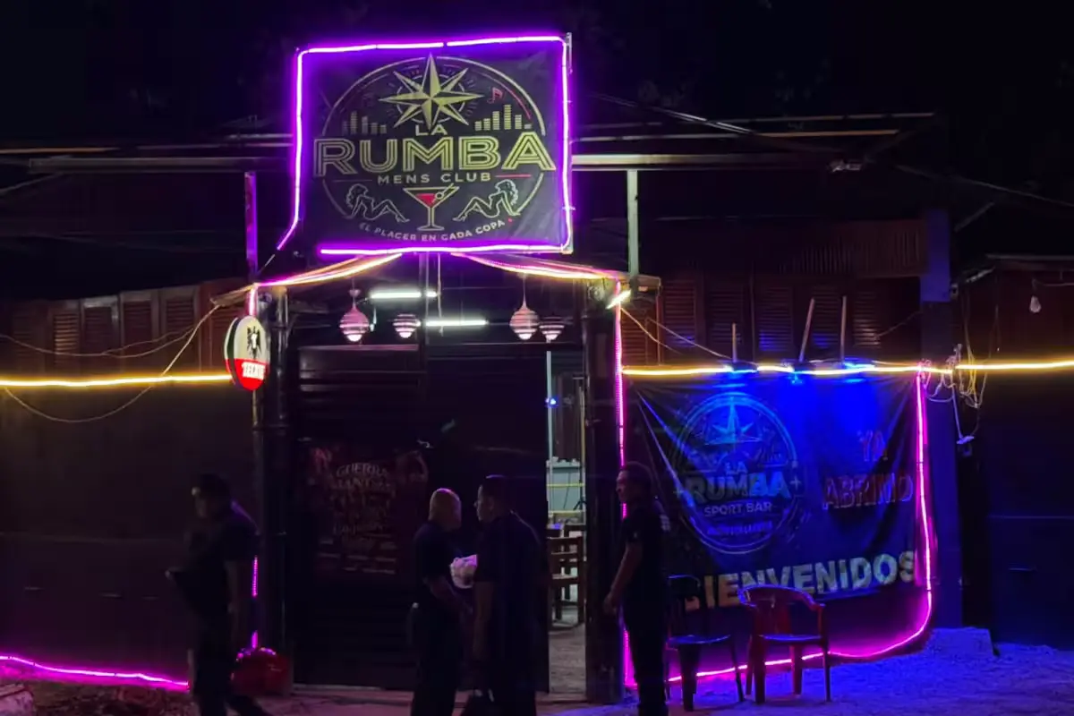 Police vehicles and officers outside Bar La Rumba in Cancun during a raid
