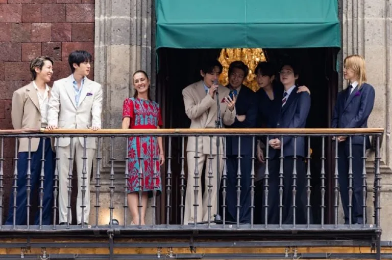 BTS members waving from a balcony at the National Palace in Mexico City