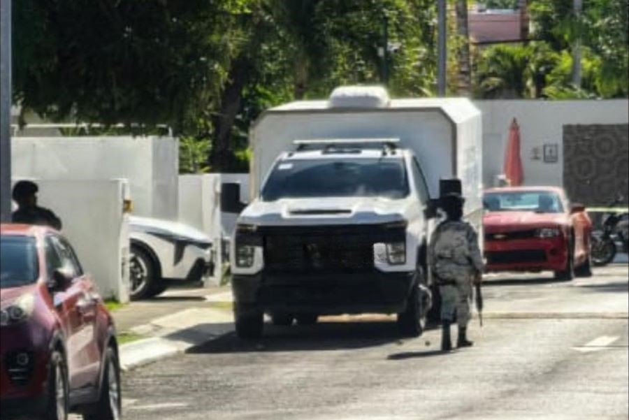 Police officers outside a home in Cancun's Real Tikal neighborhood during a raid on suspected human trafficking