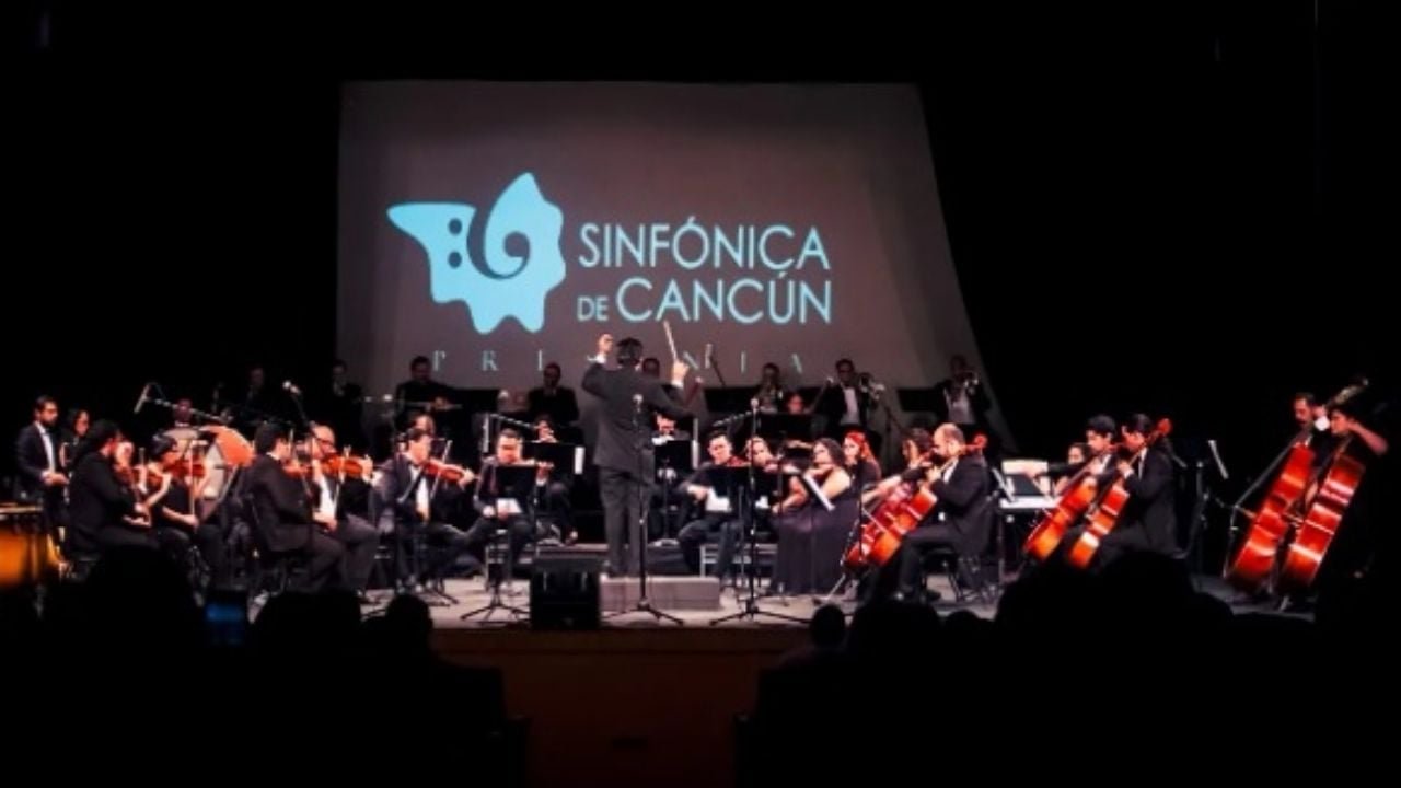 Cancun Symphony Orchestra performing on stage with conductor