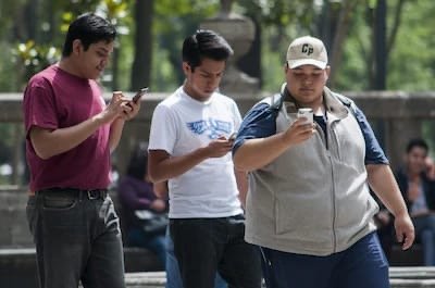 A person holding a smartphone in Chetumal, Quintana Roo, illustrating the low registration rate for mandatory cell phone lines.