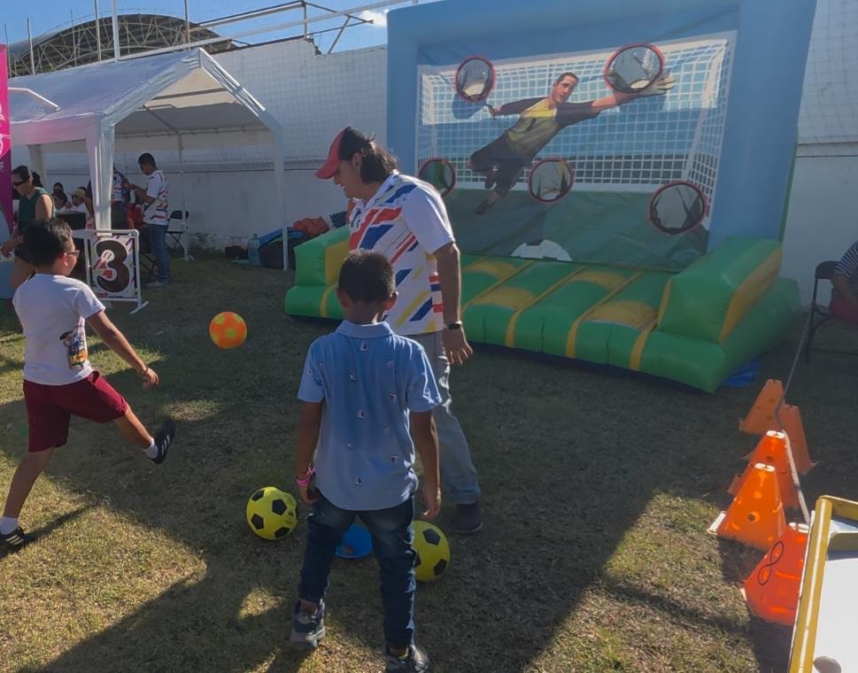 People gather at Parque de La Alameda in Chetumal for the Fiebre del Mundial event featuring soccer activities and marching bands.