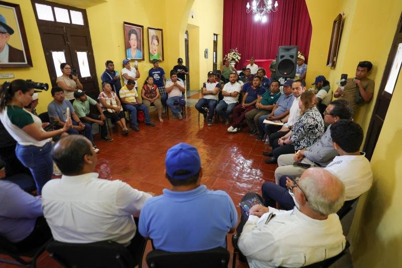 Officials and artisans seated around a table during a dialogue meeting about the Chichen Itza visitor center