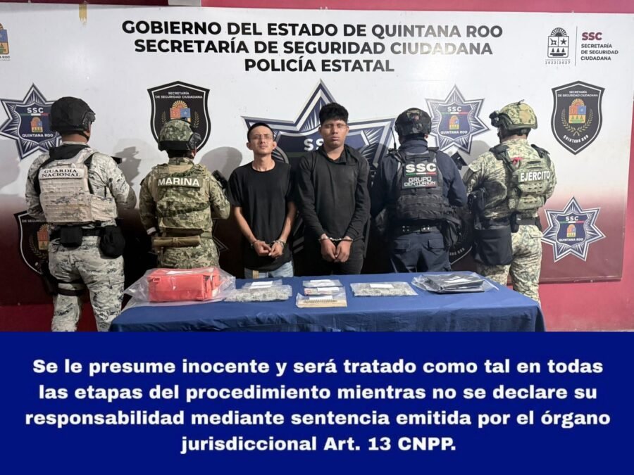 Police officers holding bags of drugs and ammunition seized during an arrest in Cancun