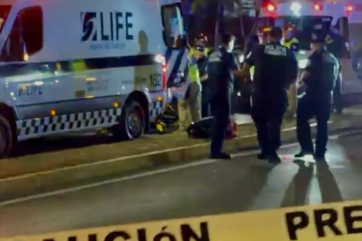 Paramedics and police officers attending to a young man hit by a vehicle on the federal highway in Playa del Carmen