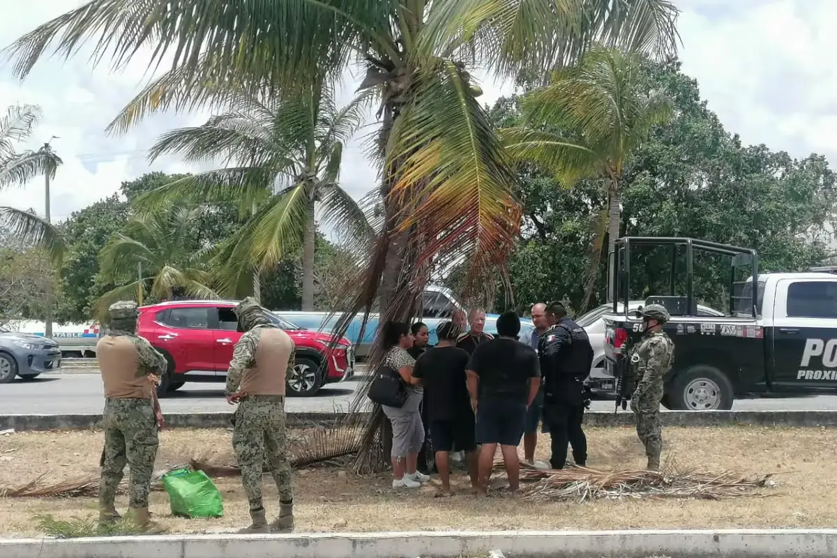 Family members confront employees outside a shoe store in Cancun after an elderly couple was robbed of their savings
