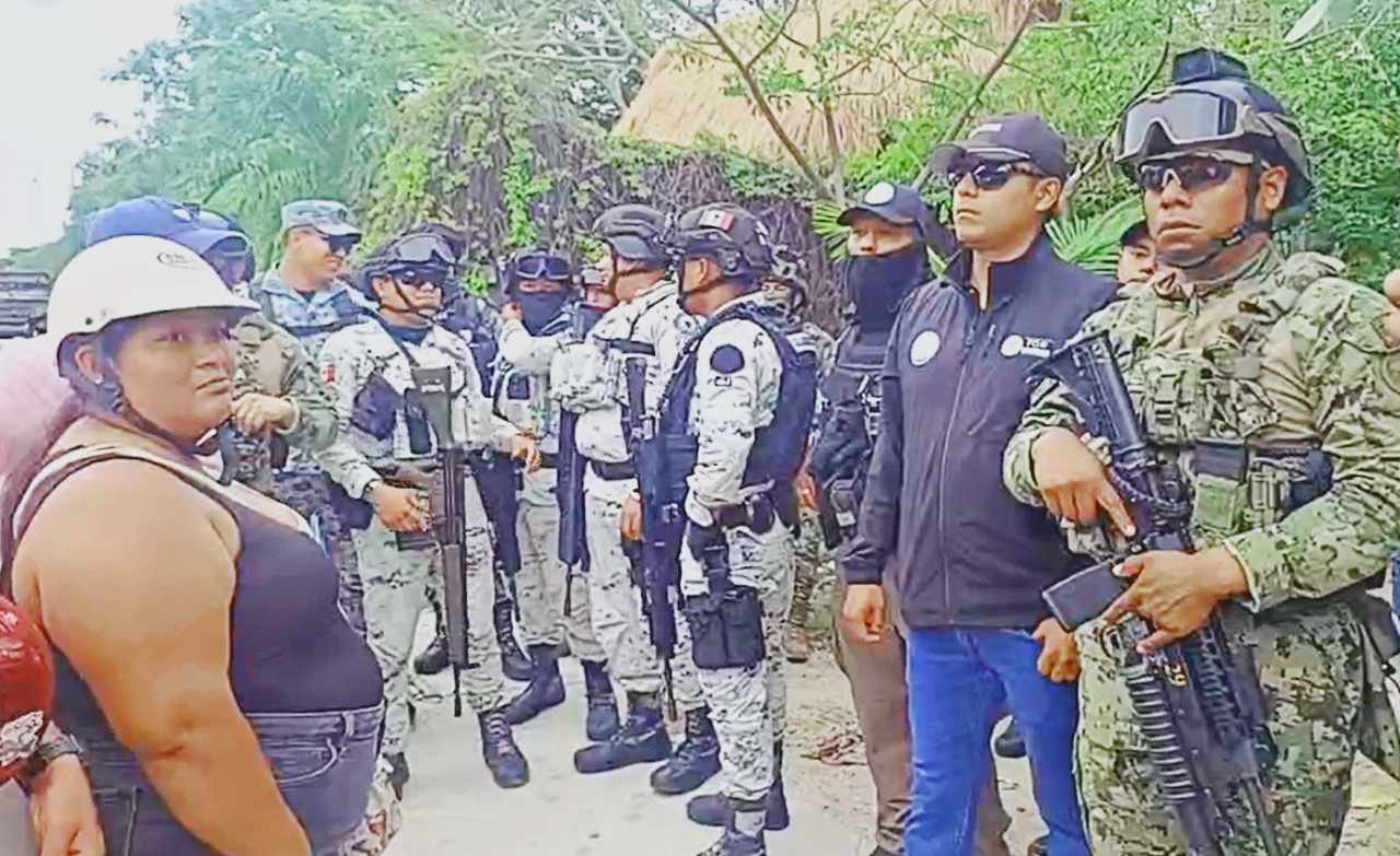 Federal police officers standing outside the Makax fishing cooperative in Isla Mujeres during a raid