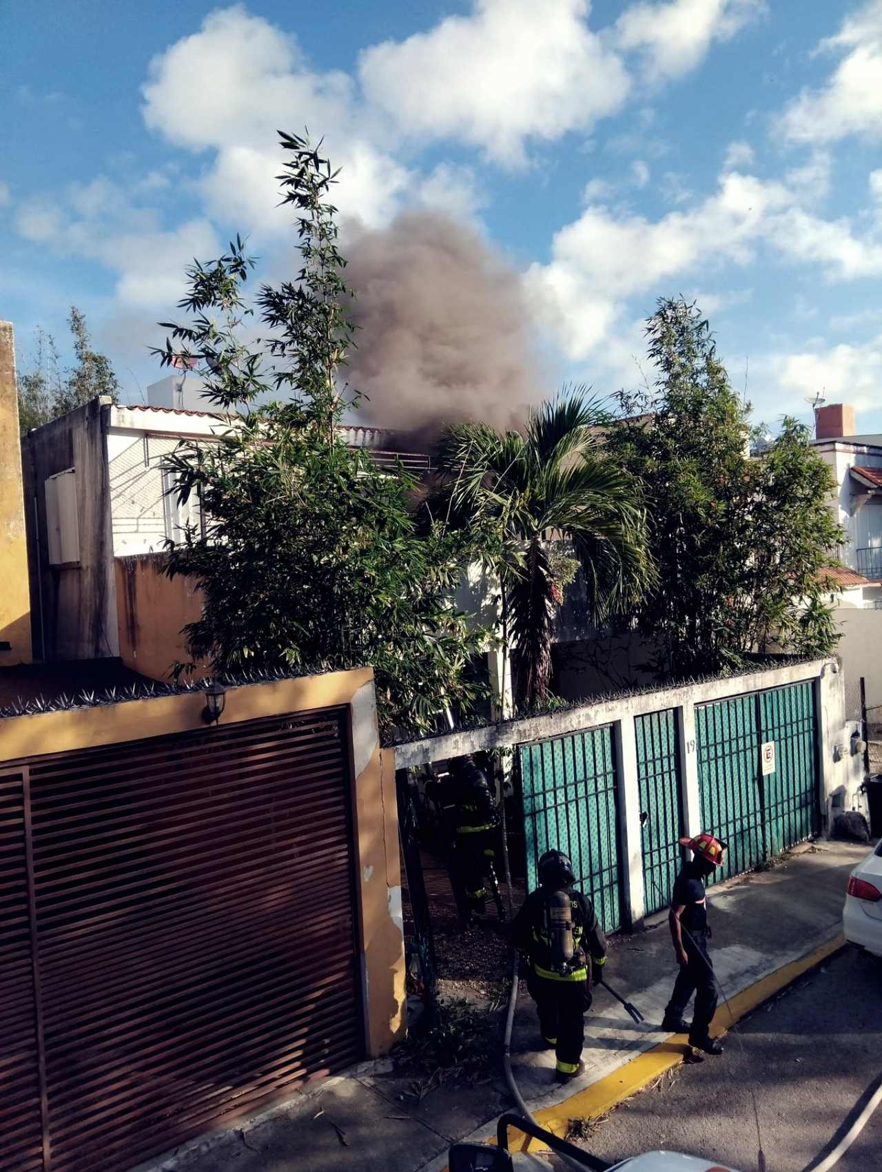 Firefighters and emergency personnel at the scene of a house fire in Playa del Carmen's Santa Fe neighborhood