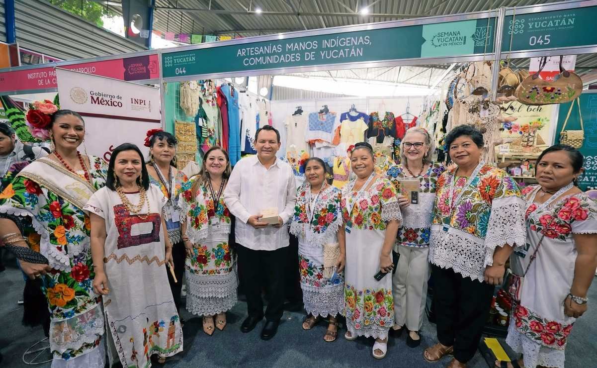 Governor Joaquin Diaz Mena speaks at the inauguration of Yucatan Week in Mexico City, surrounded by exhibitors and attendees.