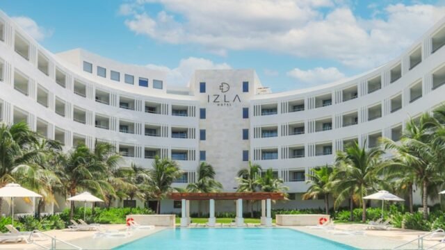 Exterior view of Izla by Fiesta Americana hotel on Isla Mujeres with curved architecture and turquoise sea