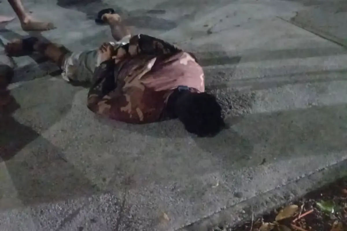 A man is held on the ground by residents after attempting to rob a pizzeria in Cancun's Paraiso Maya neighborhood.
