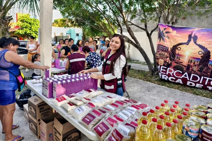 Young volunteers from Mercadito Cerca de Ti displaying beans, rice, sugar, lentils, and eggs for sale at affordable prices in Playa del Carmen