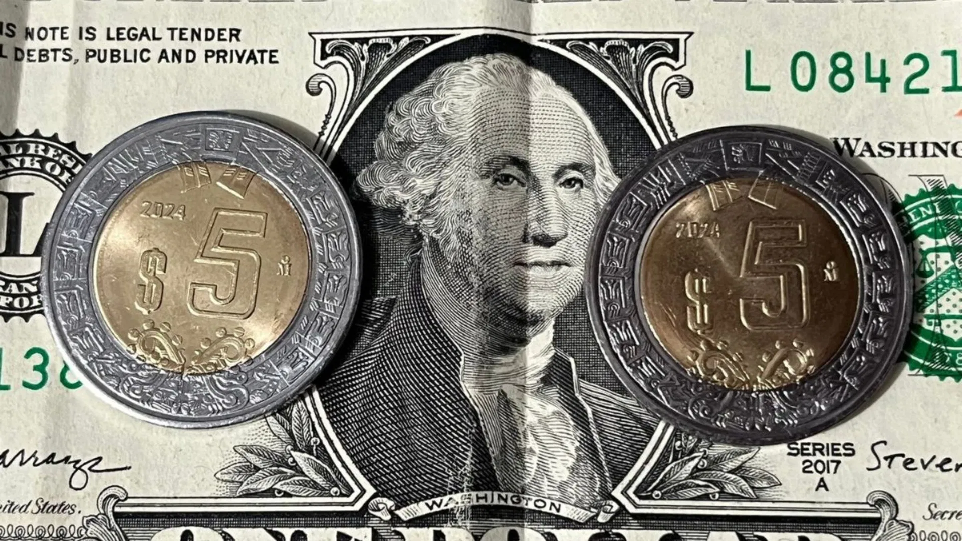 Close-up of Mexican peso and US dollar bills on a table