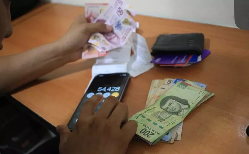 Mexican workers reviewing profit-sharing documents in an office