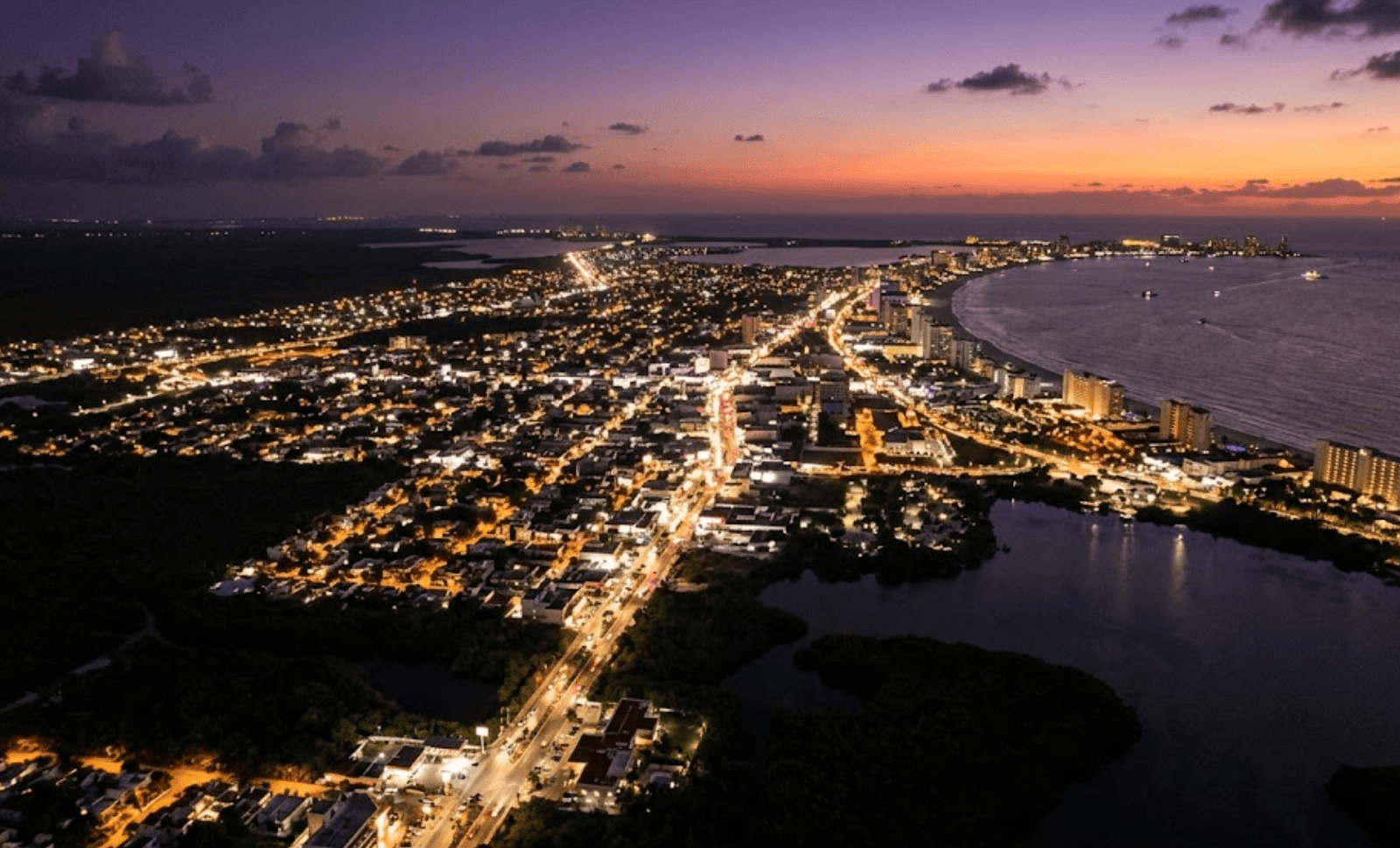 Night aerial view of the Yucatan Peninsula showing dense urban lights, indicating high electricity consumption.