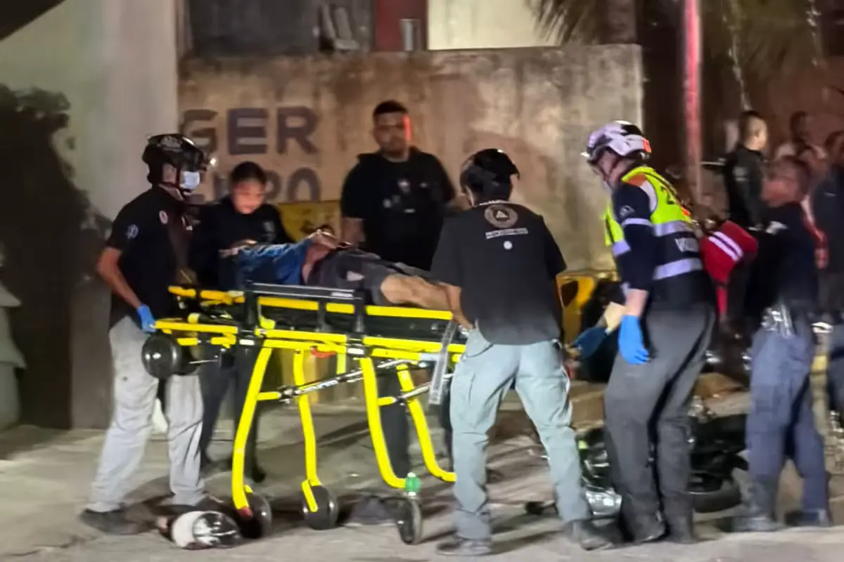 Paramedics attend to a man shot multiple times on a street in Cancun