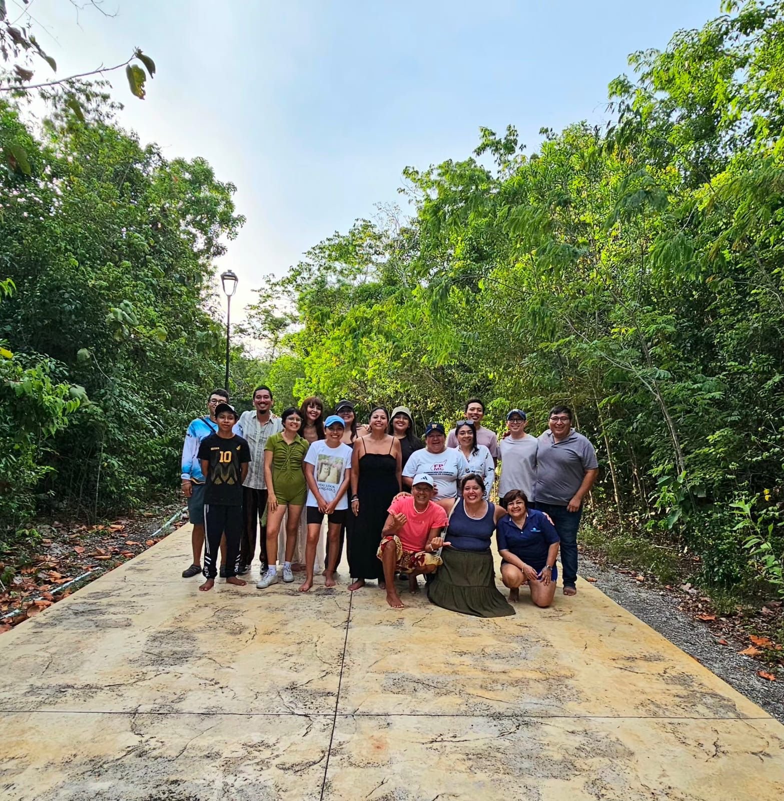 Group of people walking silently through a green park in Cozumel during a mindfulness activity for International Biodiversity Day