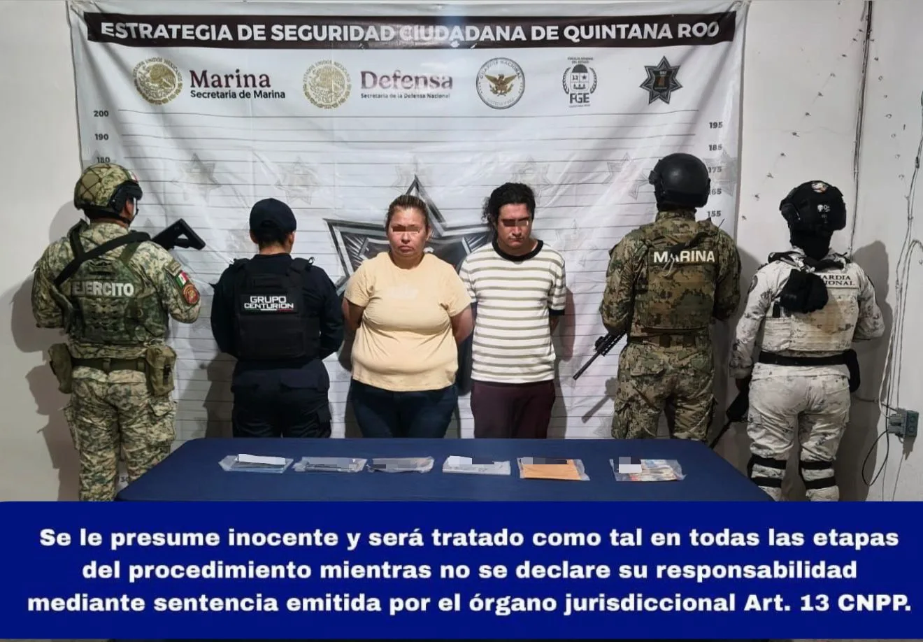 Two suspects in handcuffs being led away by police officers in Playa del Carmen