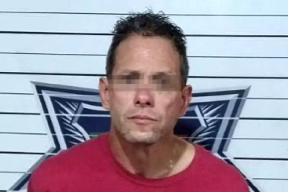 Police officers detain a man in Cancun