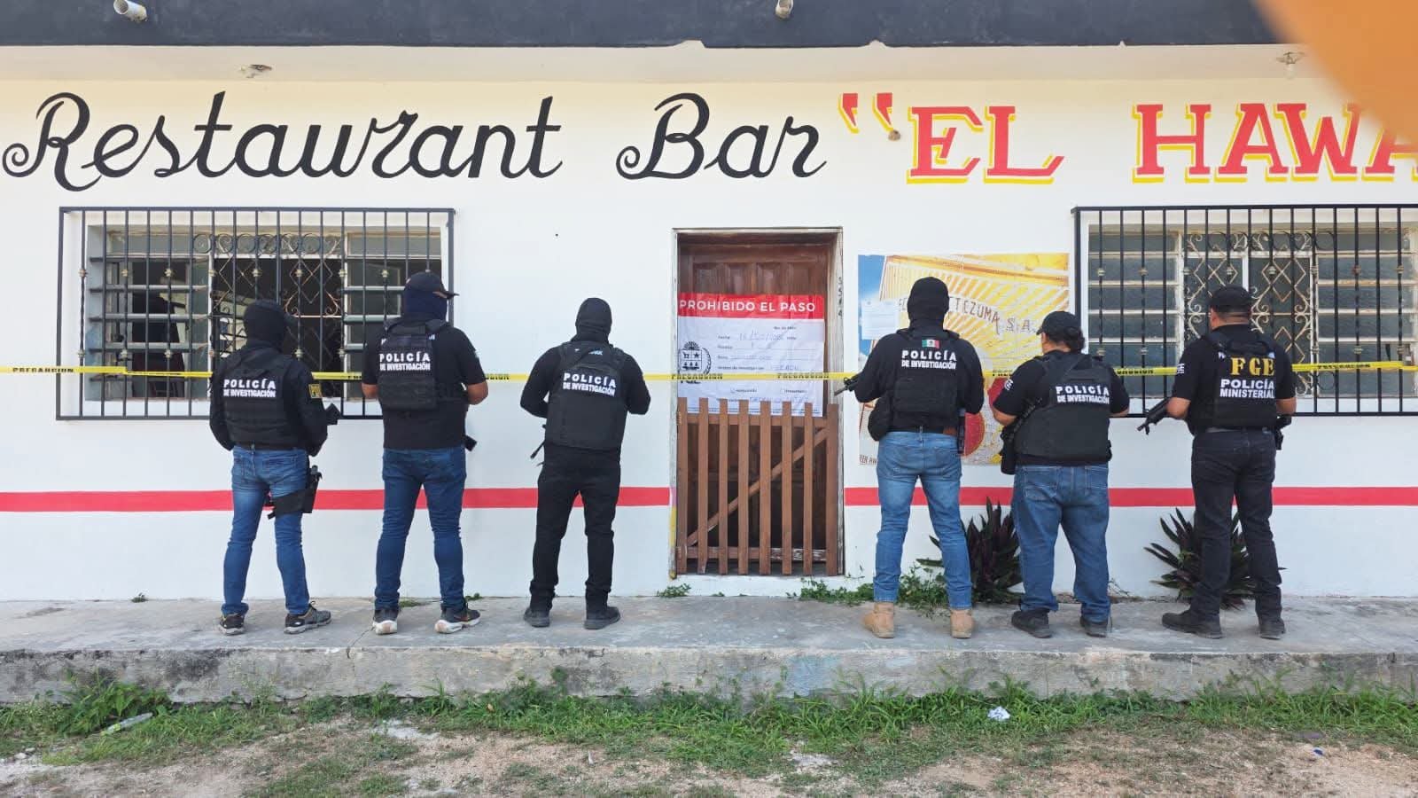 Police officers and military personnel outside the El Hawai bar in Dziuché during a raid