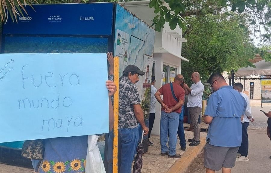 Group of protesters holding signs at the entrance of Parque del Jaguar in Tulum