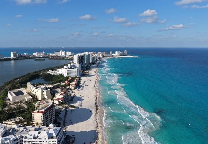 Aerial view of a beach resort in Quintana Roo, Mexico, with turquoise water and white sand.