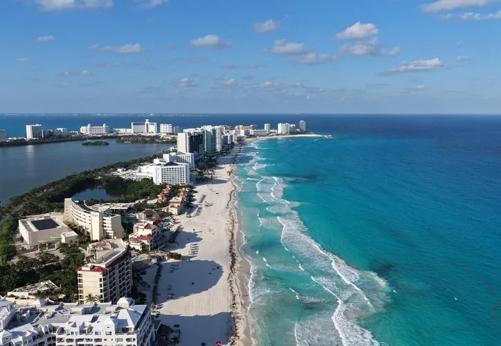 Aerial view of a beach resort in Quintana Roo, Mexico, with turquoise water and white sand.