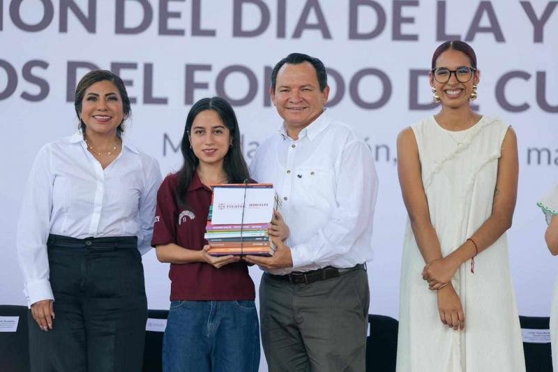 Governor Joaquín Díaz Mena hands out books to students at a Renacimiento Maya event in Mérida, Yucatán.
