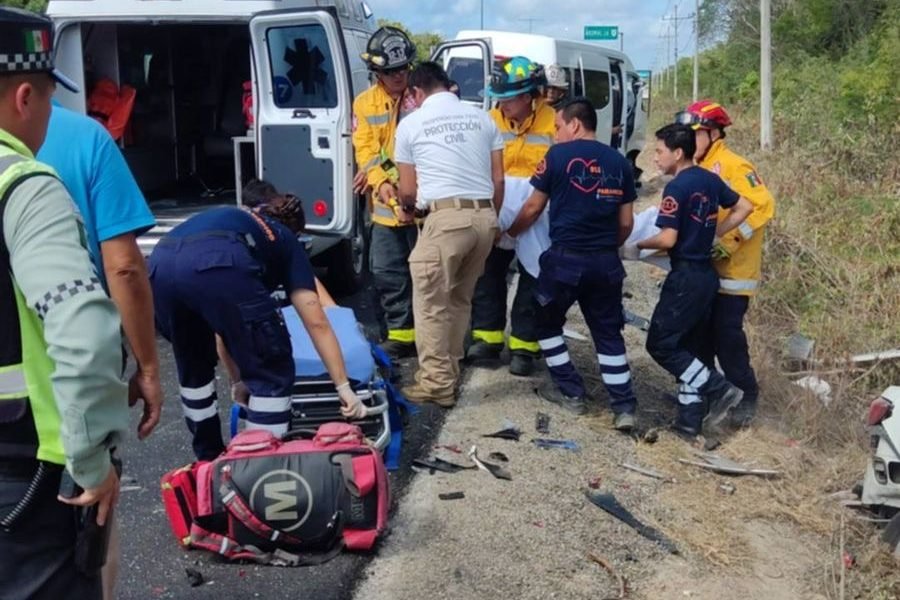 Rescue workers extricating a woman from a severely damaged vehicle on the Playa del Carmen-Tulum highway