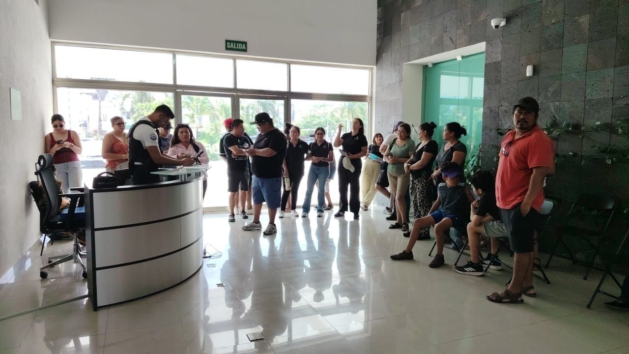 Residents holding signs protest outside CFE offices in Playa del Carmen