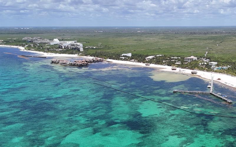A floating sargassum barrier installed along the coastline of Maroma Beach in the Riviera Maya.