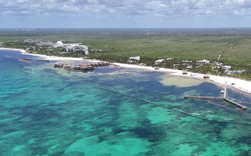 A floating sargassum barrier installed along the coastline of Maroma Beach in the Riviera Maya.