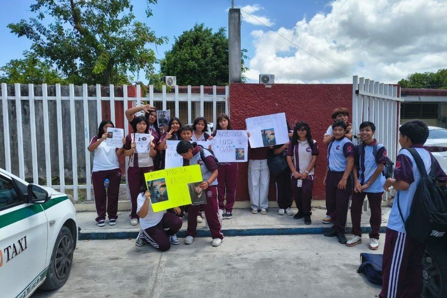 Students gathered around a makeshift altar with candles and photos at a school in Cancun