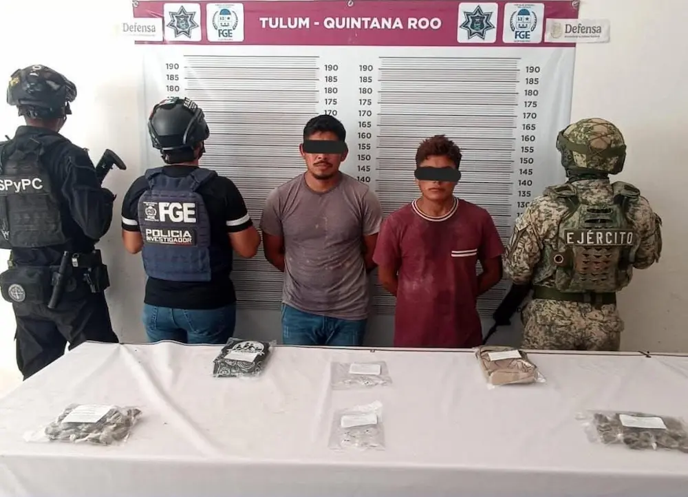 Police officers stand next to evidence bags containing seized drugs during a drug bust in Tulum.
