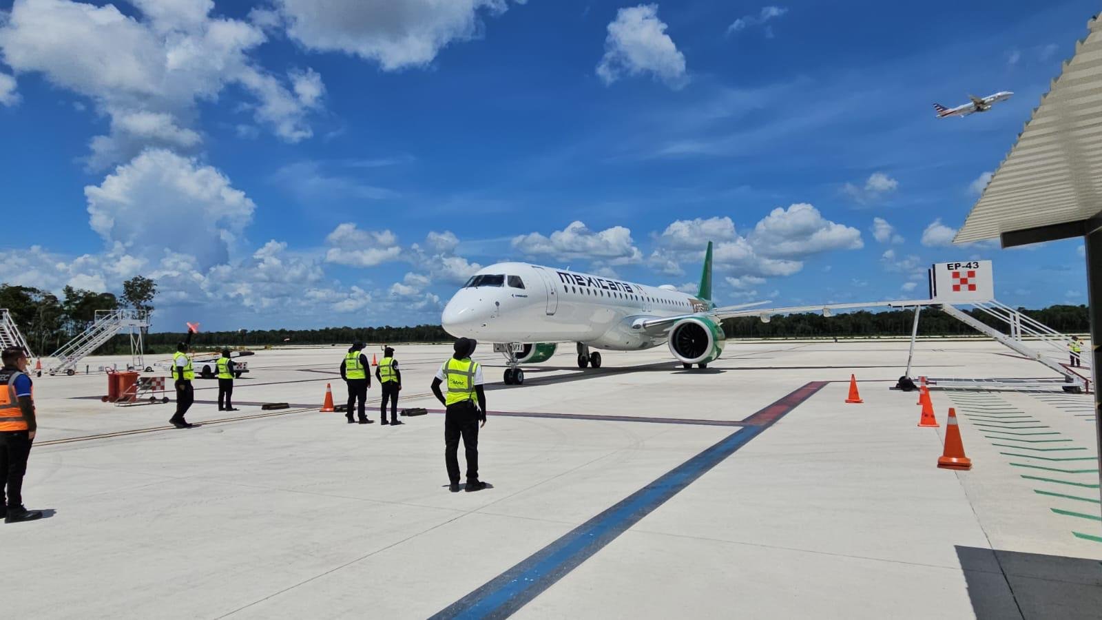 Workers at Tulum International Airport hold signs protesting labor harassment and document retention by a private security firm