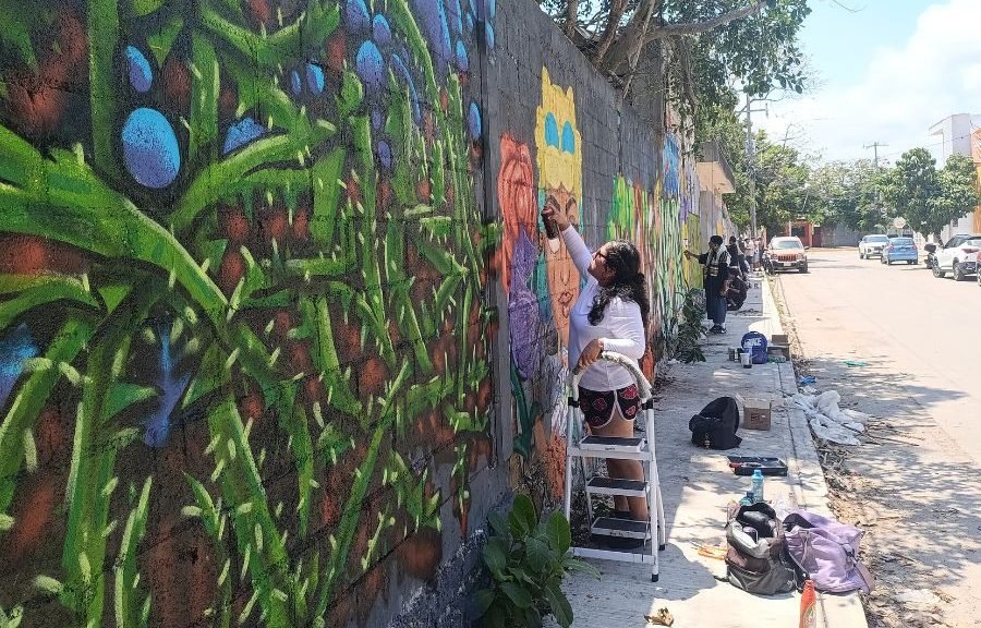 Urban artists painting colorful murals on a wall during World Graffiti Day event in Playa del Carmen